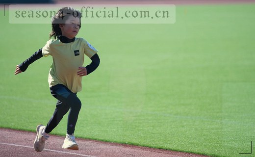 一位女生在图书馆书架前翻开手中的小说。
